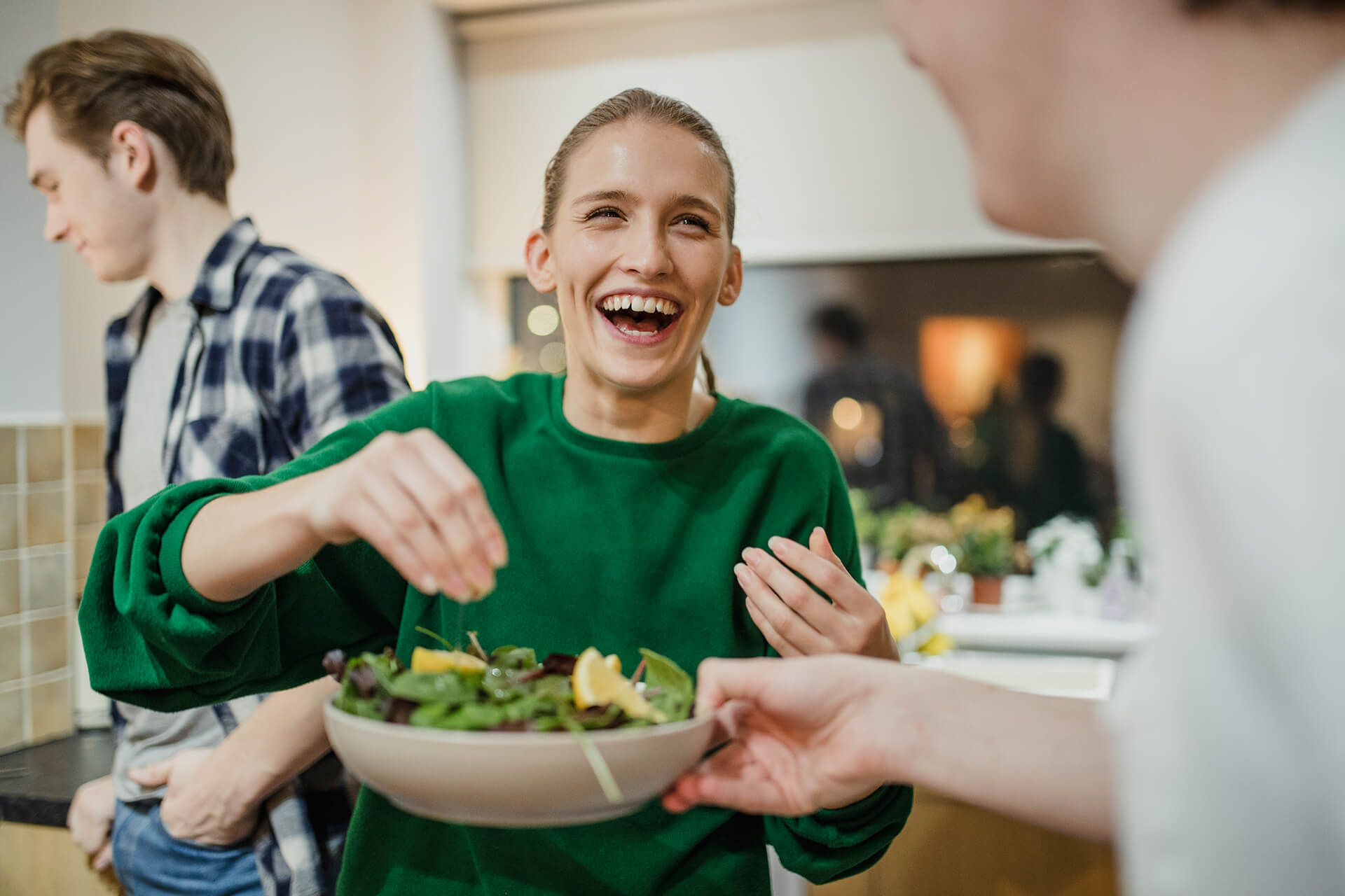 Frau mit Salatteller beim WG-Kochen