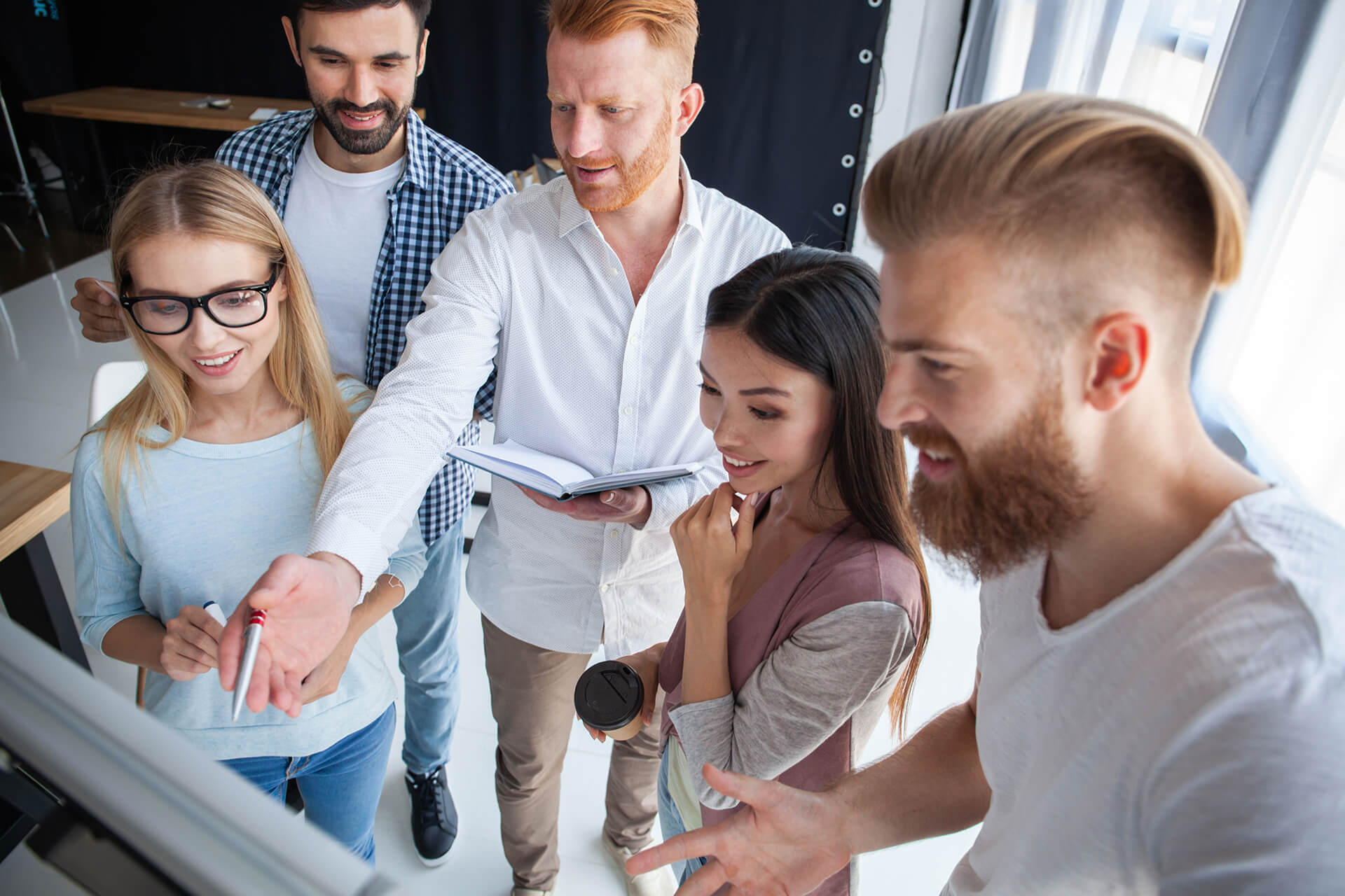 Ein junges Team ararbeitet ein Projekt an einem Flip-Chart