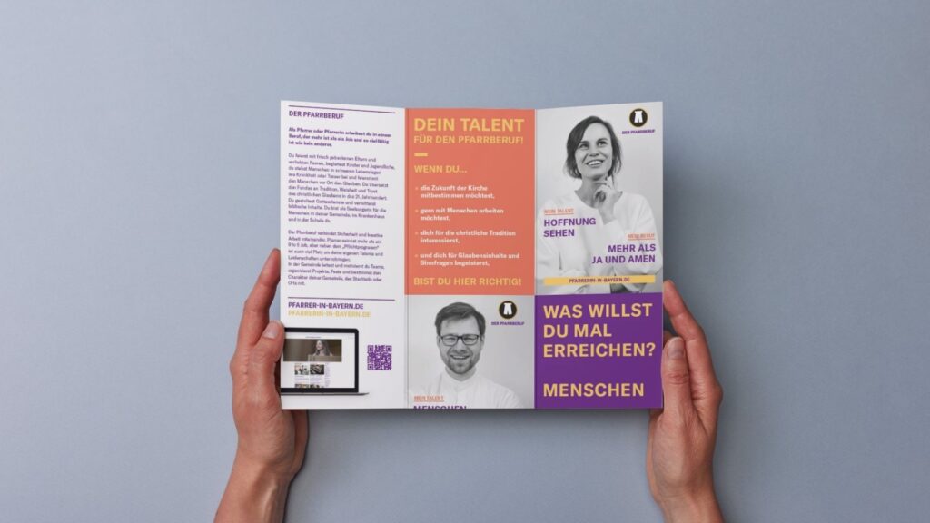 Eine Person hält eine aufgeschlagene, deutschsprachige Broschüre über Berufe in der Kirche vor sich, die Fotos von lächelnden Menschen, Textblöcke und einen QR-Code auf hellgrauem Hintergrund zeigt.